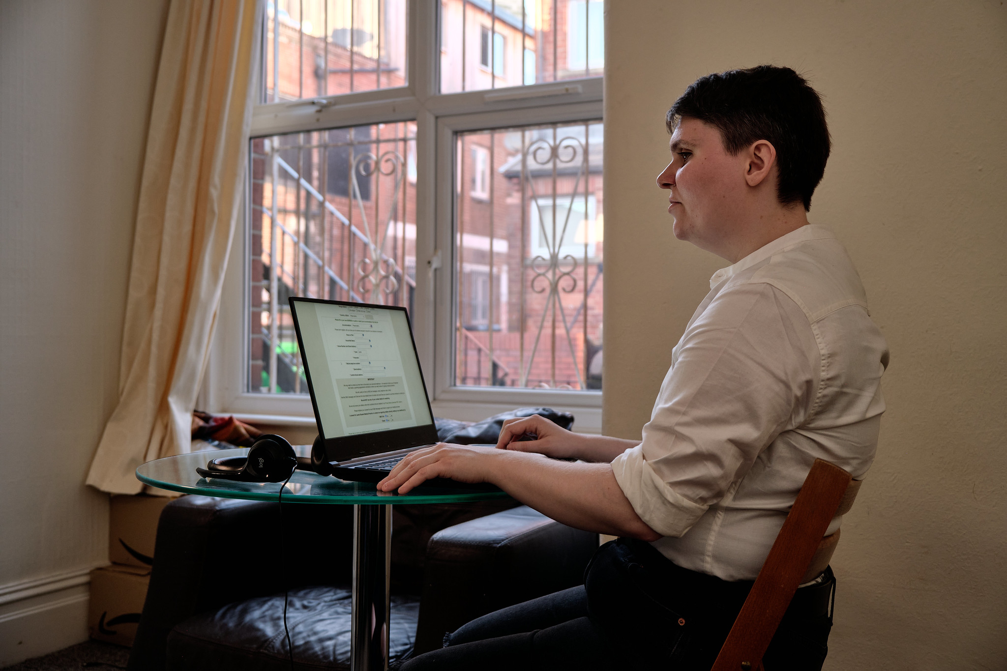 A young person with a visual impairment at a laptop.