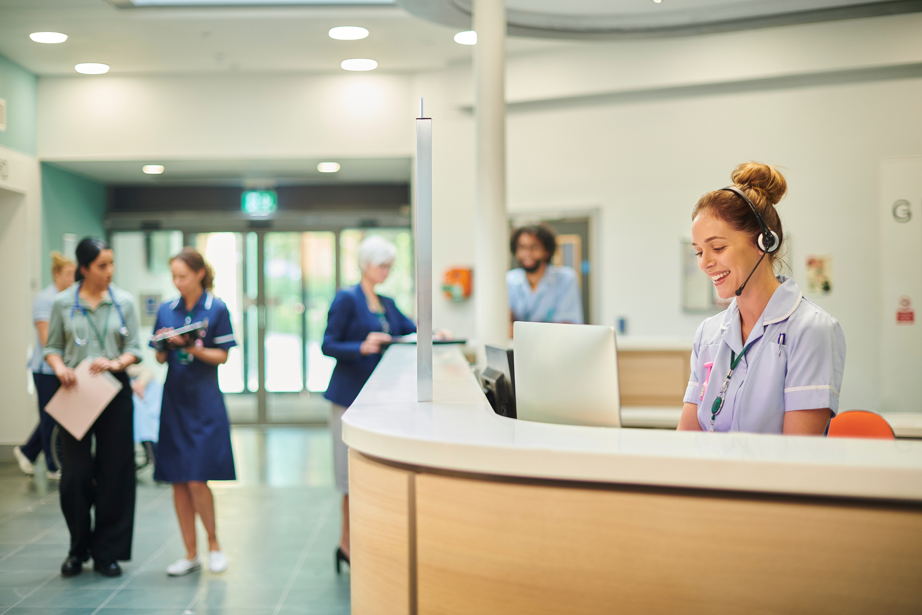 A nurse on a hospital reception desk.