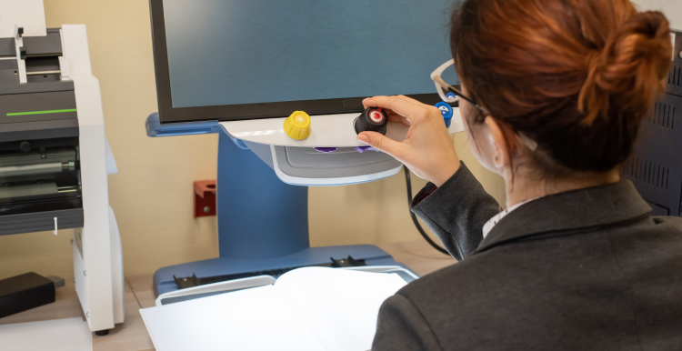 A young person with accessibility needs sat at a computer.