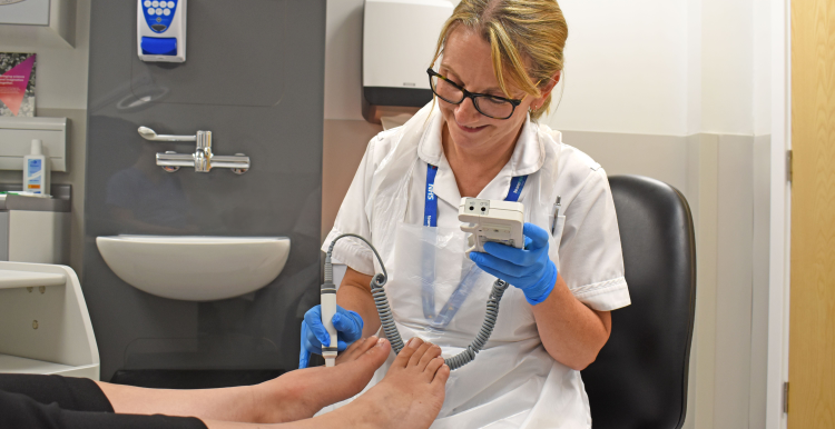 A healthcare professional in a podiatry clinic with a patient