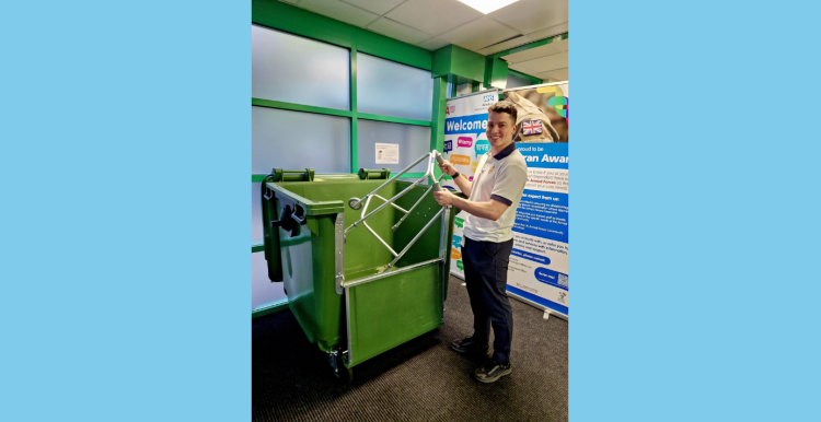 A young person placing a walking aid into a recycling bin at a hospital.