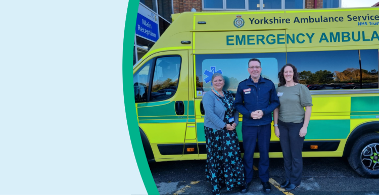 NHS staff and a guest standing next to an ambulance outside a hospital.