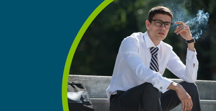 A young man in a shirt and tie sat on a step outside smoking a cigarette.
