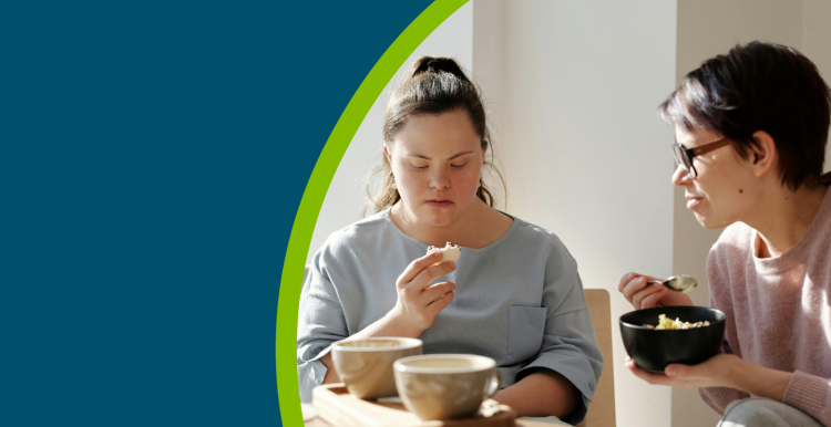 Two women sat down eating breakfast.