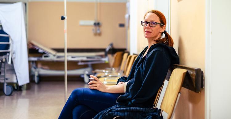 Female patient sitting in hospital ward hallway waiting room