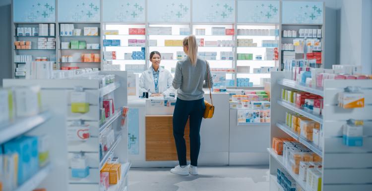 Woman at a pharmacy counter having a consultation with a female pharmacist.