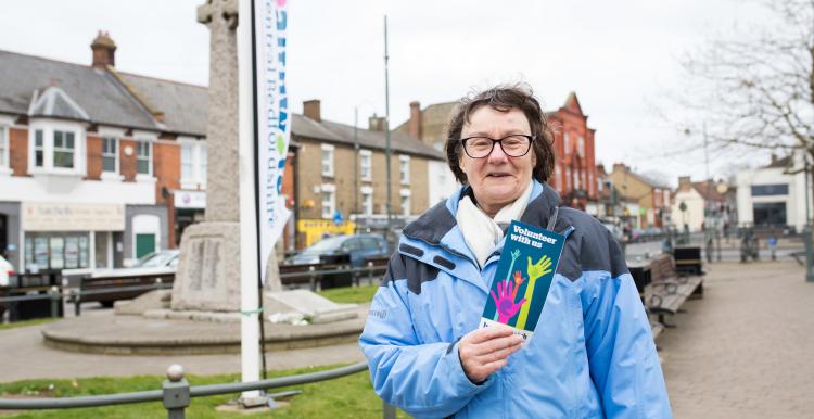 woman holding up healthwatch leaflet