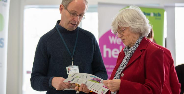 man and woman looking at healthwatch leaflet