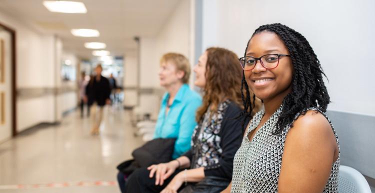 Three women sat waiting in a hospital corridor