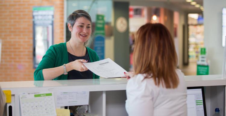 woman handing form to receptionist