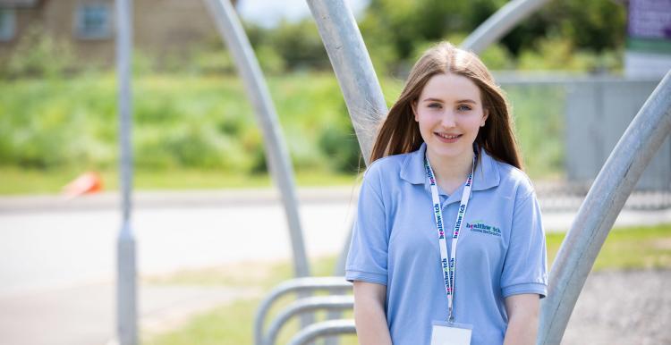 Young volunteer smiling at the camera outside