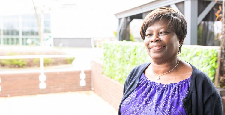 Woman in a purple top smiling at the camera