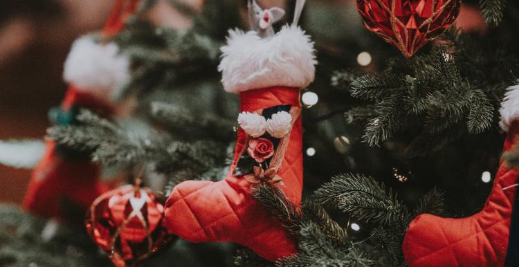 A Christmas tree with red and white festive baubles and Santa boots