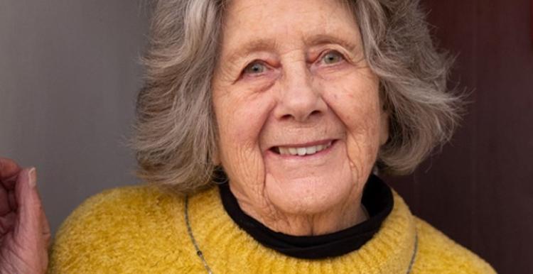 Elderly lady smiling at her front door, advertising the Joint Forward Plan by West Yorkshire Health and Care Partnership