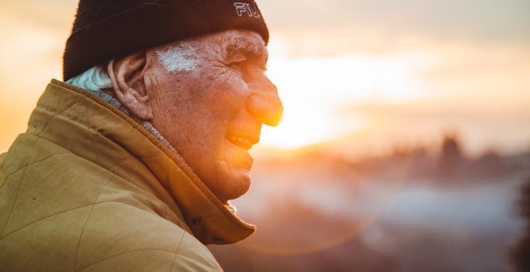 Older man looking out at the sun