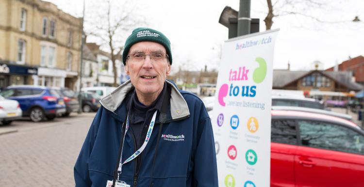 Man stood in front of a Healthwatch banner