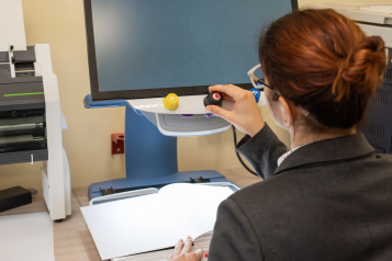 A young person with accessibility needs sat at a computer.