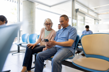 Husband and wife sat in a hospital waiting area