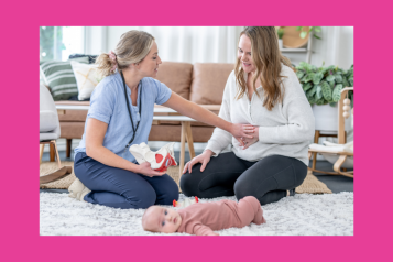 Healthcare professional sat with a mother and baby