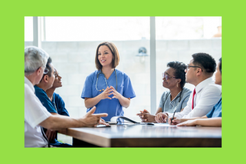 Physician associates and doctors sat around a table talking