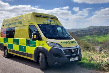 An ambulance pulled up in a rural location.