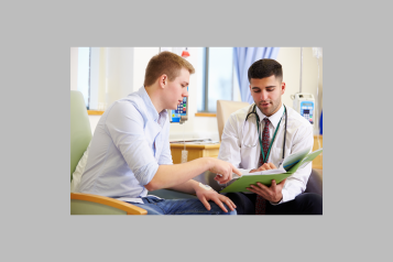 A doctor talking to a patient at a GP practice.