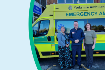 NHS staff and a guest standing next to an ambulance outside a hospital.