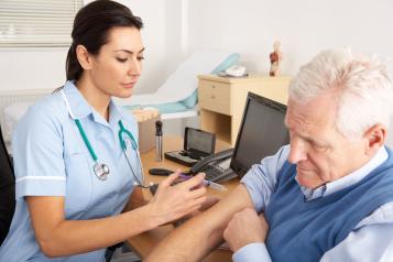 An NHS nurse giving an older man an injection at a GP practice.