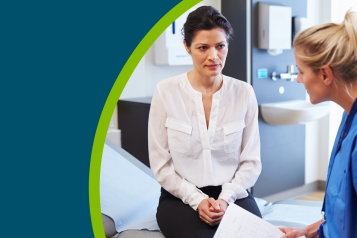 Female patient and doctor have consultation in hospital room.