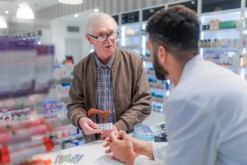Young pharmacist explaining to customer how to be dosing medication