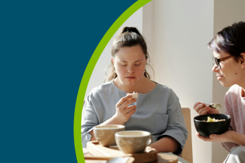 Two women sat down eating breakfast.