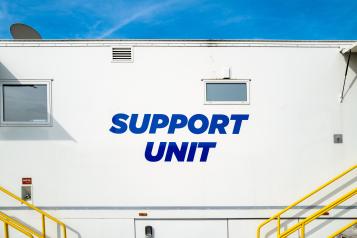 Large mobile cancer screen unit showing the support unit screening trailer and yellow hand rails to allow patients to board