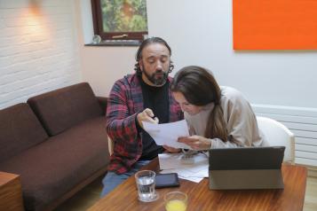 Man and disabled woman doing paperwork at table at home
