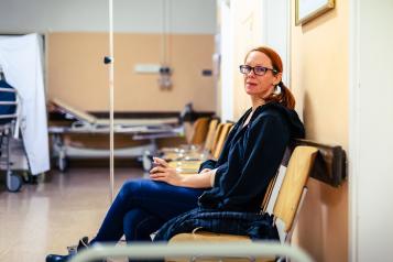 Female patient sitting in hospital ward hallway waiting room
