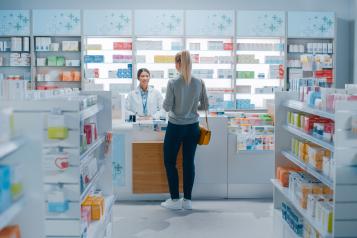 Woman at a pharmacy counter having a consultation with a female pharmacist.