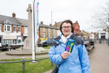 woman holding up healthwatch leaflet
