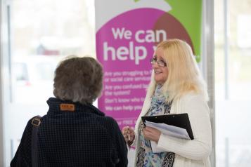 two people stood talking at a healthwatch event