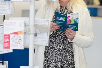 person stood reading healthwatch leaflet