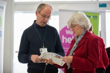 man and woman looking at healthwatch leaflet