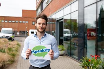 man holding speak up sign