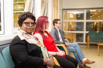 three people sat down in waiting room