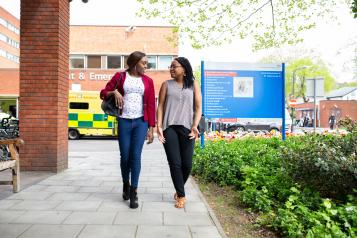 Two people walking outside A&E