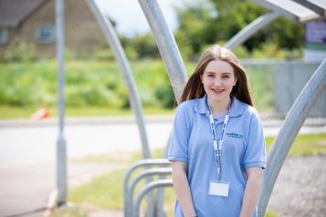 Young volunteer smiling at the camera outside