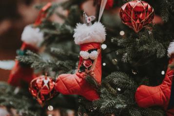 A Christmas tree with red and white festive baubles and Santa boots