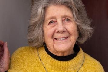 Elderly lady smiling at her front door, advertising the Joint Forward Plan by West Yorkshire Health and Care Partnership