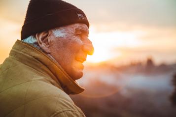 Older man looking out at the sun