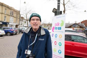 Man stood in front of a Healthwatch banner