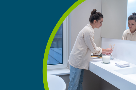 A young woman putting air freshener in the bathroom