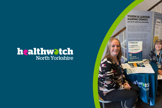 Two women sit smiling at a round table with a teal Healthwatch North Yorkshire tablecloth. The background shows a staircase with white railings and a wooden handrail.