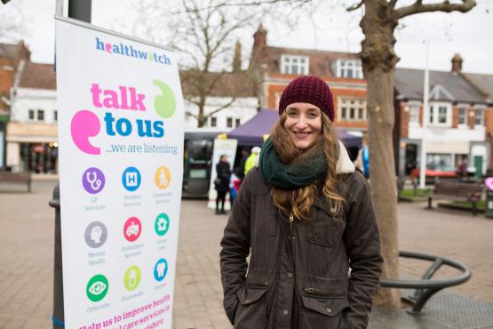 Woman stood in front of a Healthwatch banner